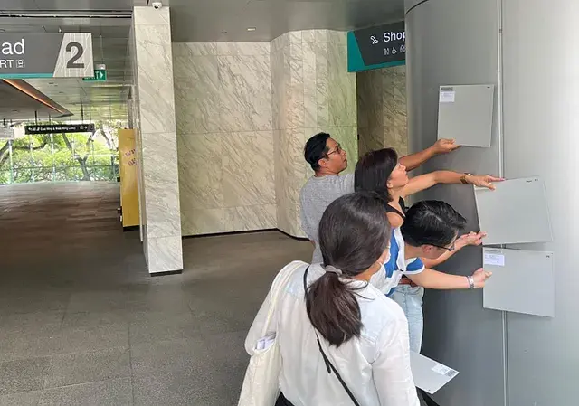 Project team comparing aluminium coating samples in daylight