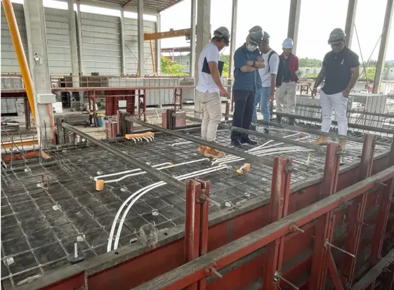 Project team checking MEP conduits and cast-in services before a PPVC floor slab is poured