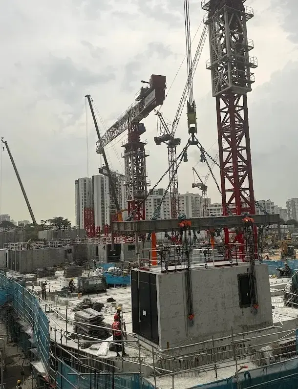 Tower cranes lifting a PPVC module into position on a residential construction site