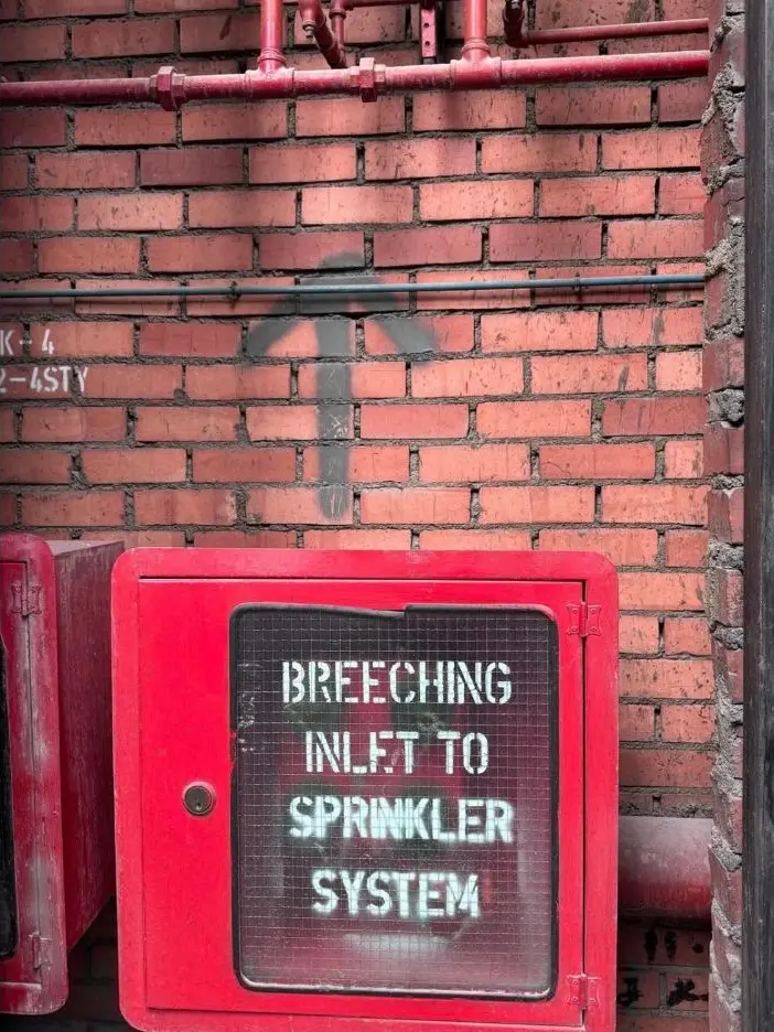 Firefighting breaching inlet and sprinkler system pipework