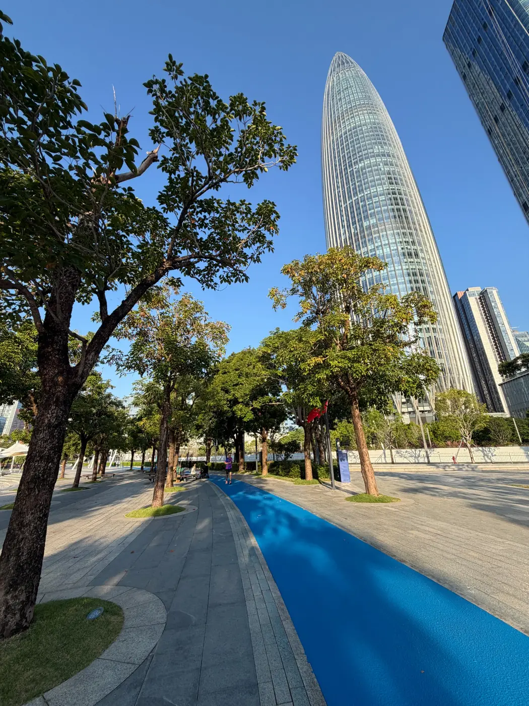 Tree-lined running path and skyline at Shenzhen Talent Park