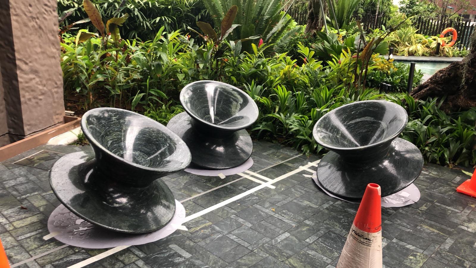 Carved dark natural stone seating pieces with veining continuing over the curved surfaces