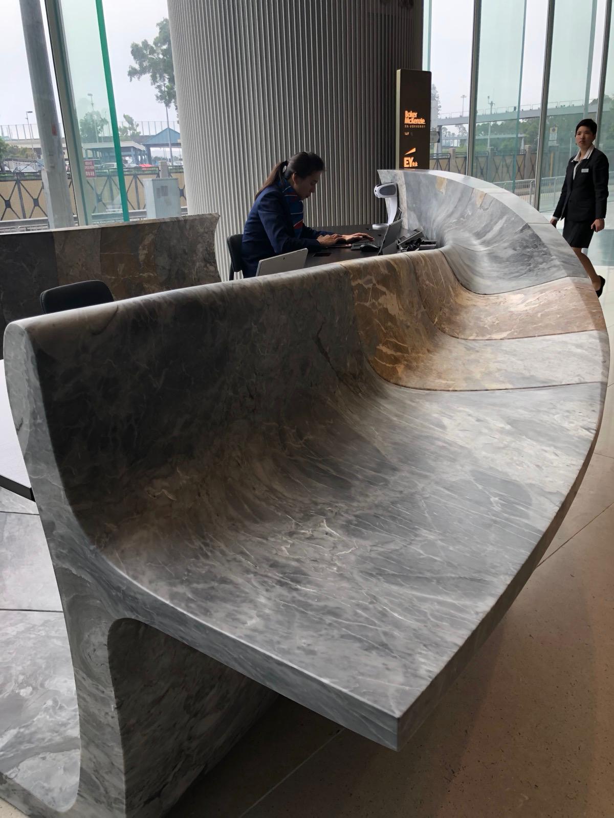 Large curved natural stone reception counter being worked on site