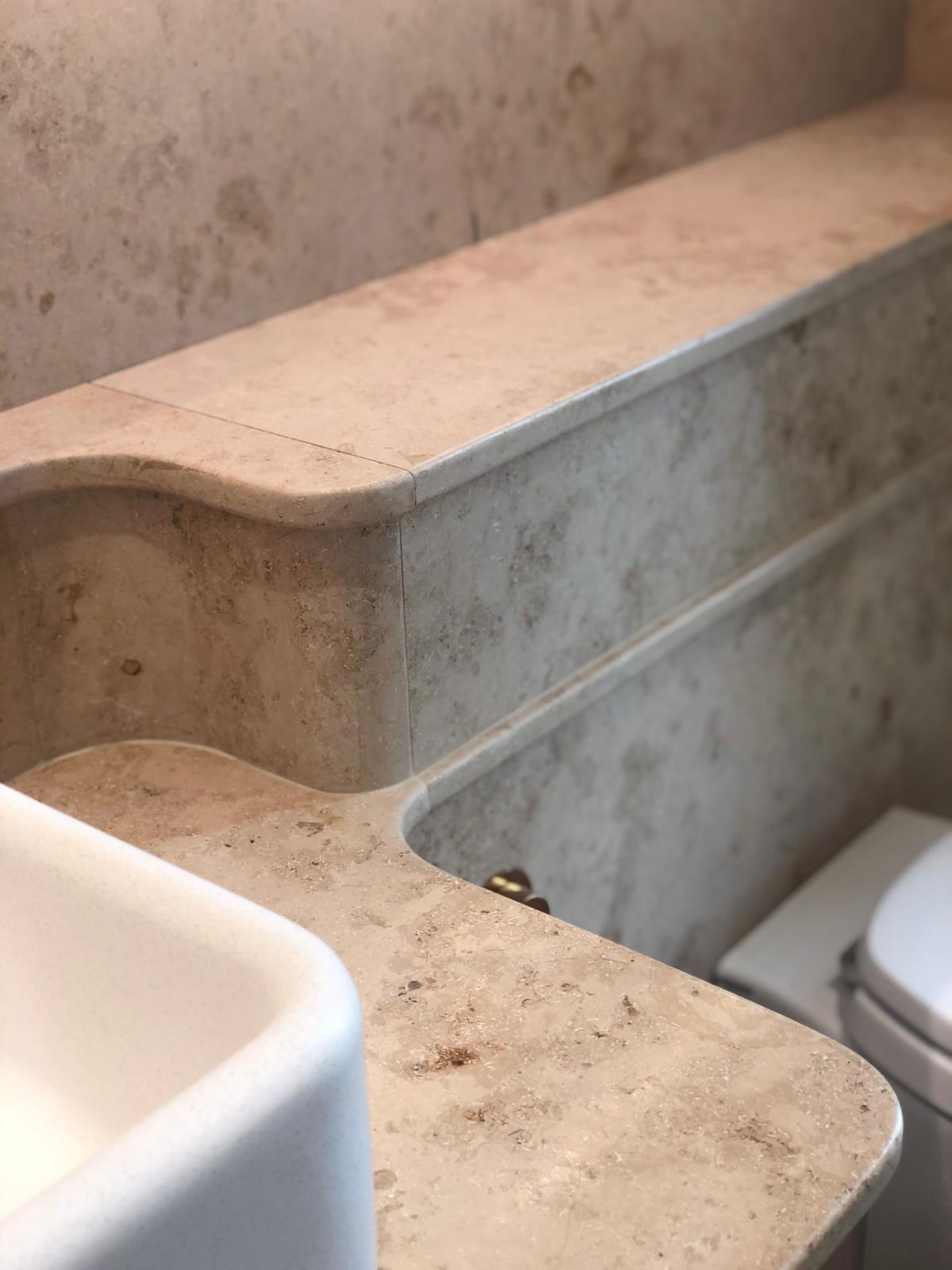Rounded natural stone vanity edge showing a shaped return