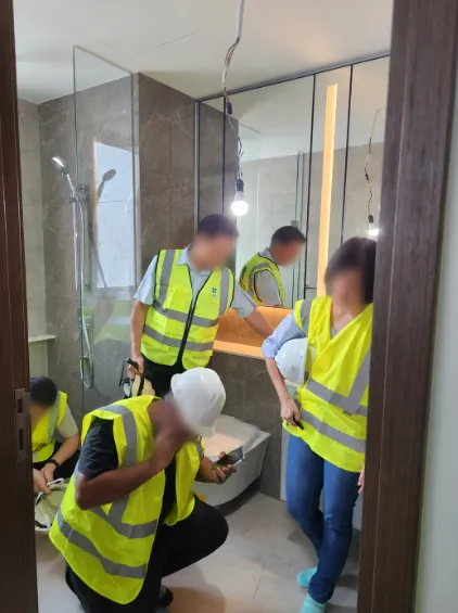 Project team conducting a detailed quality inspection inside a completed residential bathroom
